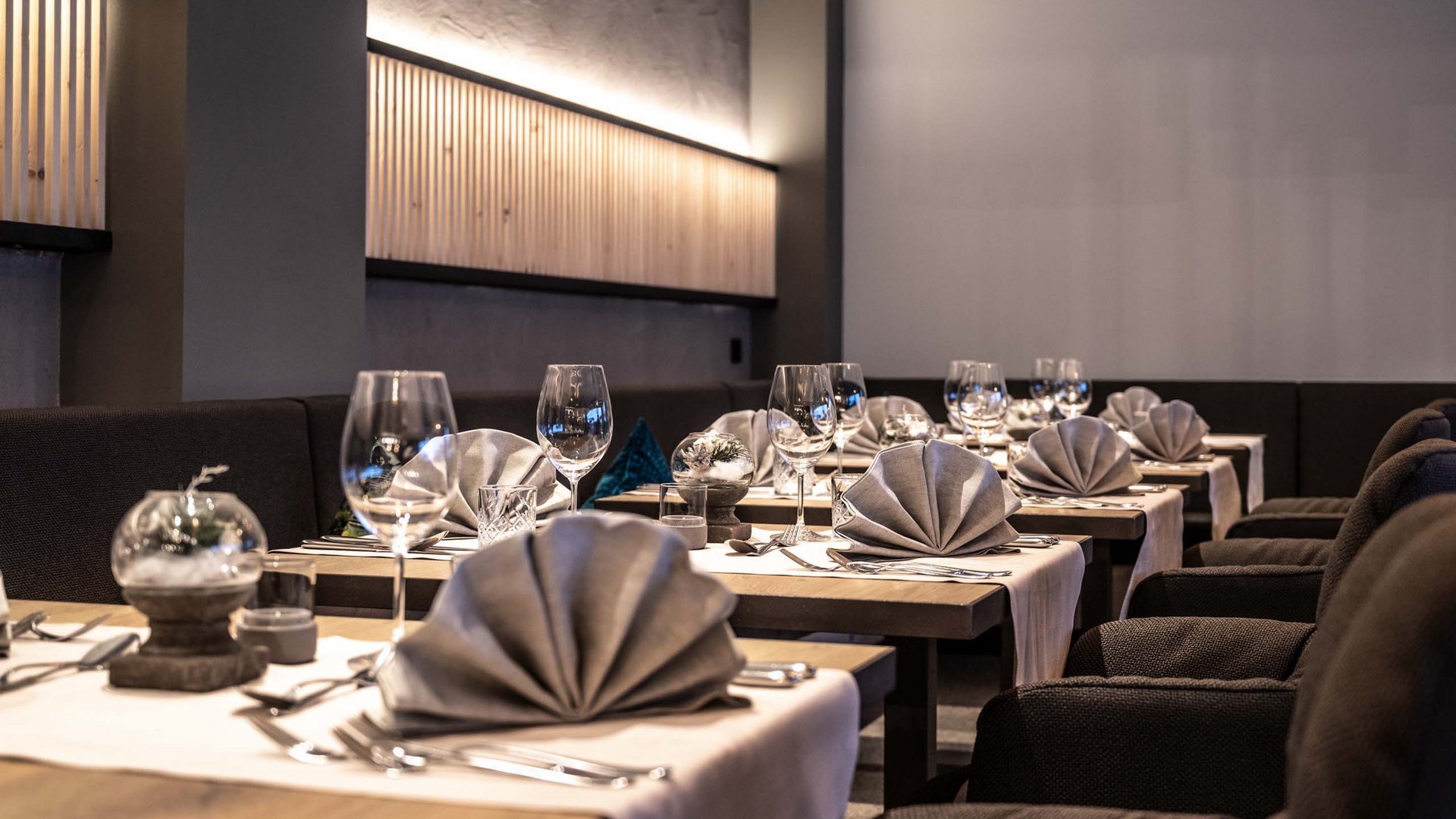 Hotel Schmung – Ihr Hotel auf der Seiser Alm Elegantes Restaurant mit eingedeckten Tischen und gefalteten Servietten